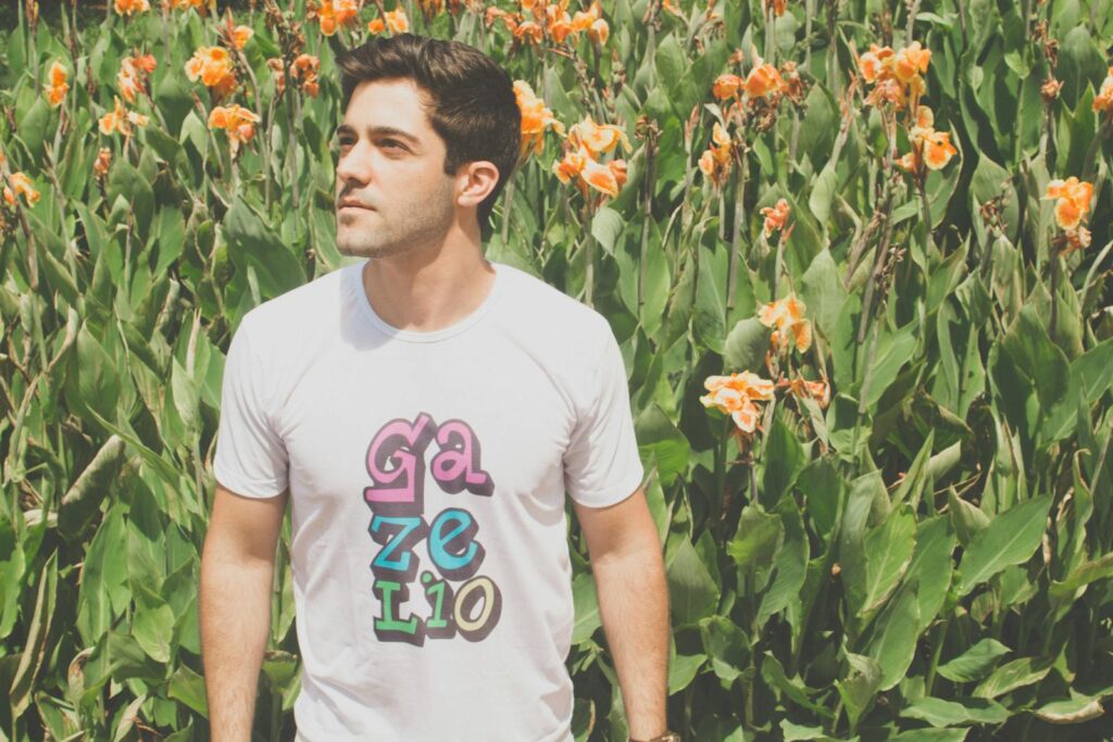 Photo by Pixabay A young man poses confidently amidst colorful flowers and lush greenery in summer.